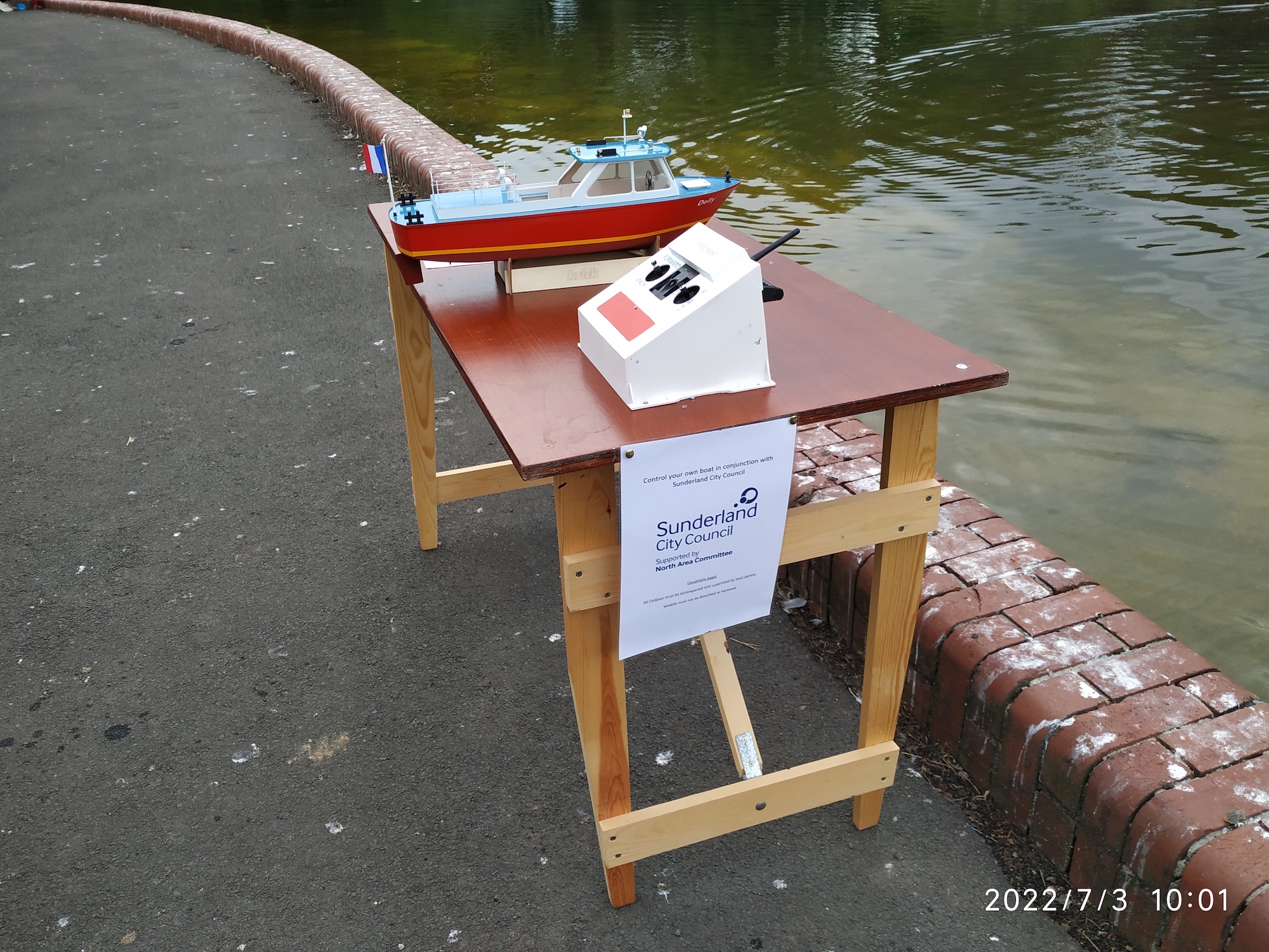 picture of a table beside the boating lake with one of the constructed model boats ready for use.